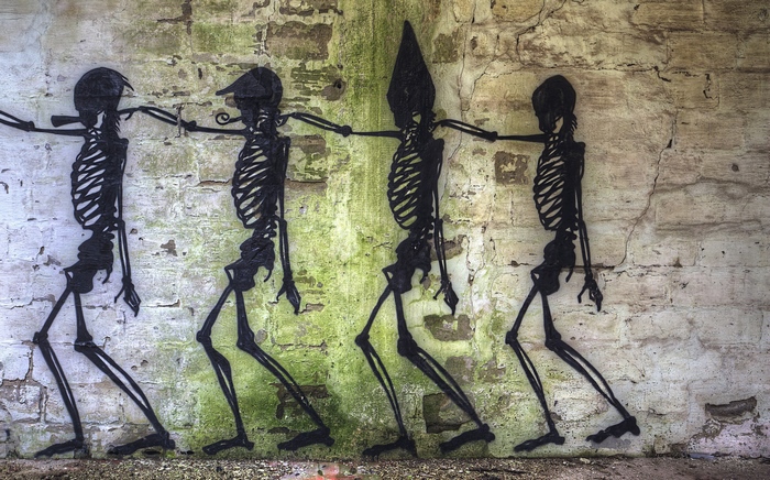Graffiti of skeletons walking on a brick wall