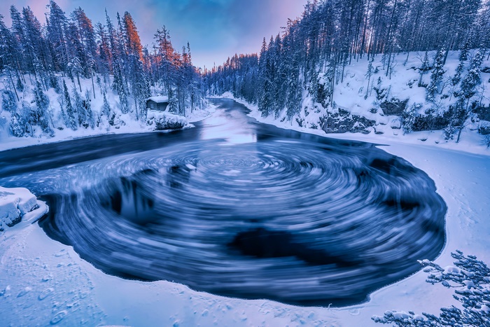 Winter river with swirling water and snow-covered trees