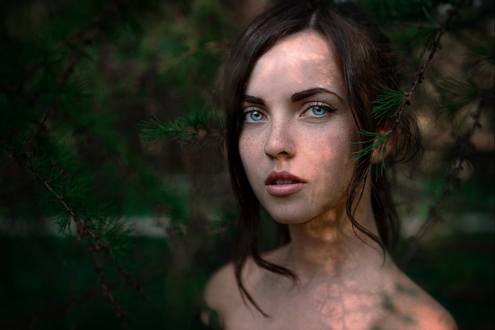 Woman with blue eyes and freckles in forest