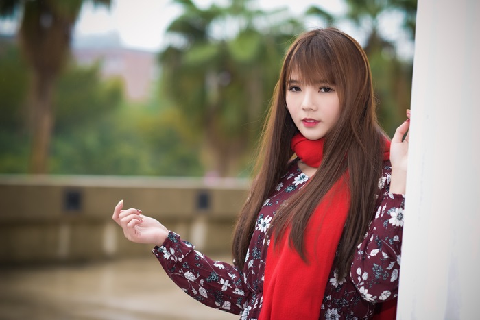 Asian woman with long brown hair and red scarf