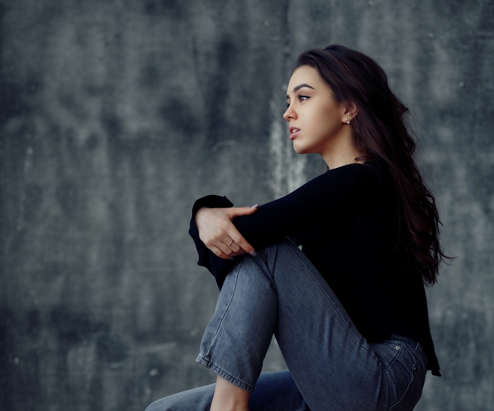 Woman with long dark hair sitting