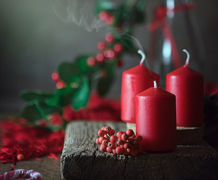 Red candles with holly berries and candy cane
