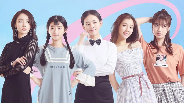 Five young women posing against a pastel background