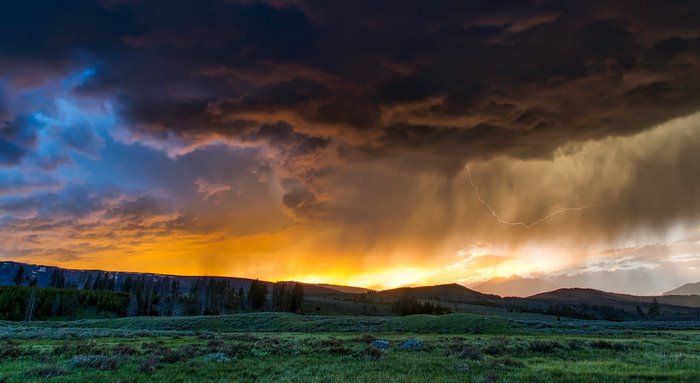Thunderstorm with lightning over a prairie at sunset