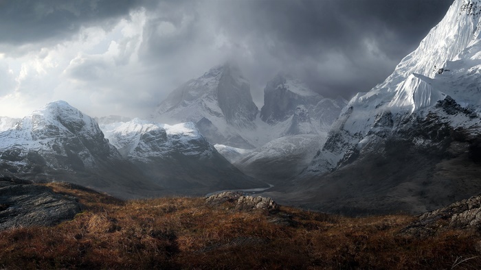 Snow-capped mountains under cloudy sky
