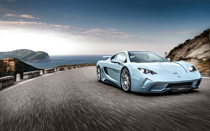 Vencer Sarthe sports car driving on a coastal road