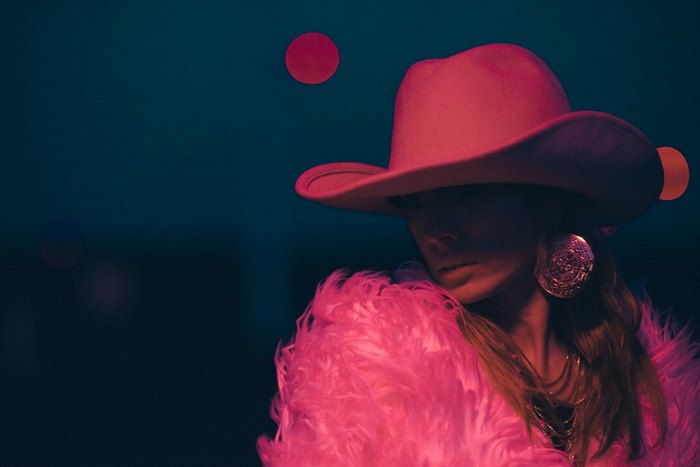 Woman in pink cowboy hat and fur coat