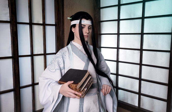 Cosplayer holding books in traditional Chinese attire