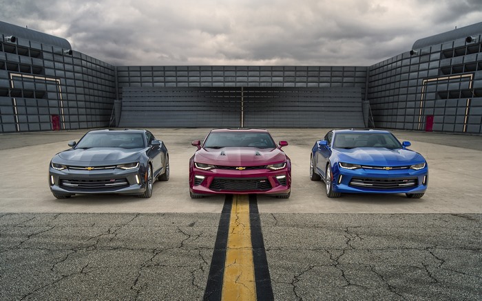 Three Chevrolet Camaros in front of a building