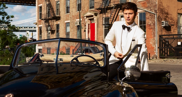 Ansel Elgort in a white suit by a vintage car