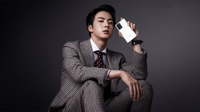 Kim Seok-jin from BTS holding a Samsung phone