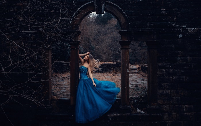 Woman in a blue dress in ruins