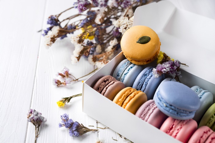 Box of colorful macarons with dried flowers