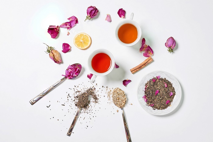 Tea, roses, lemon, and cinnamon on a white background