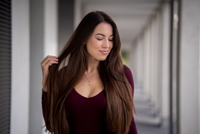 Woman with long brunette hair and necklace