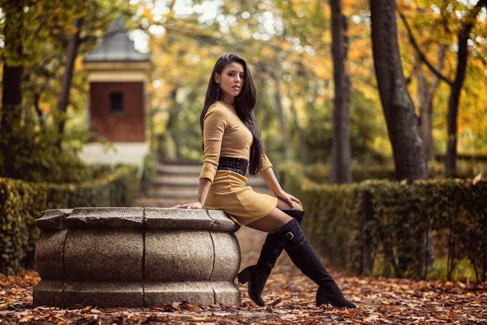Woman with long black hair wearing a yellow dress and boots