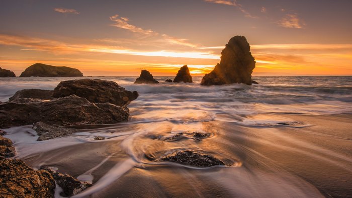 Ocean sunset with rock formations on the beach