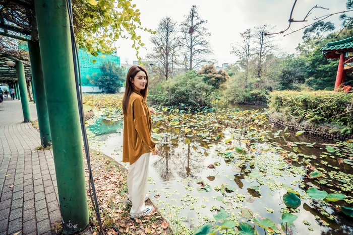 Asian woman with brunette hair by a pond