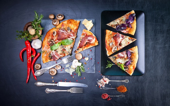 Still life of pizza with prosciutto and mushrooms