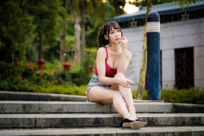Asian woman with brunette hair sitting on steps