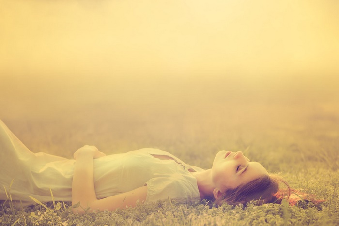 Young woman lying in a grassy field