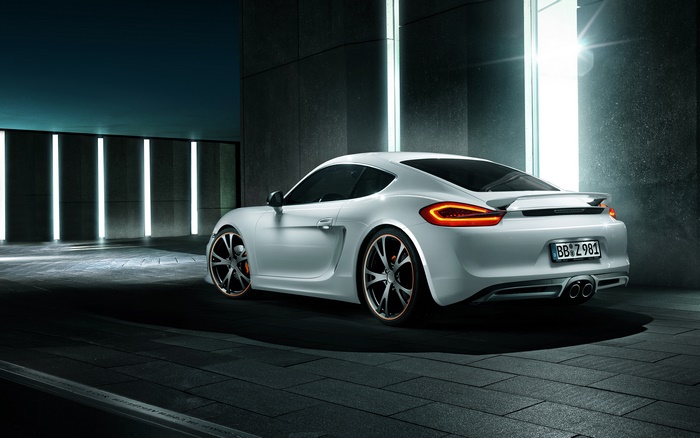 White Porsche Cayman S parked in modern architecture