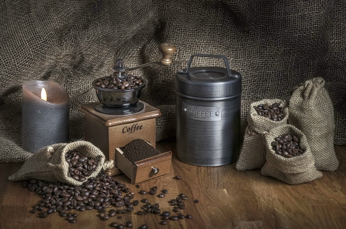 Still life with coffee grinder, beans, and candle