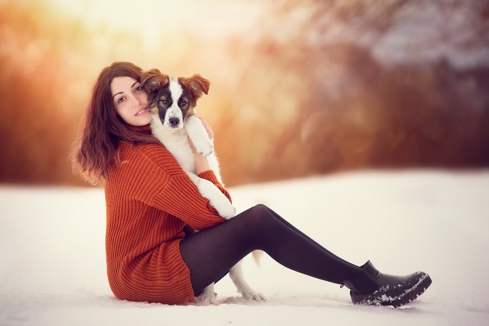 Woman hugging a dog in the snow