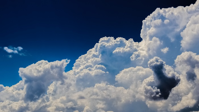 Cumulonimbus clouds against a dark blue sky