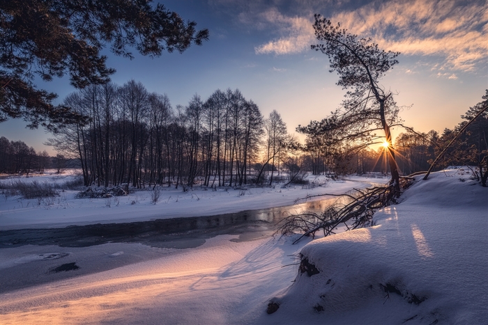 Winter river at sunset with trees