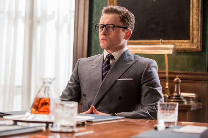 Eggsy from Kingsman wearing a suit and glasses
