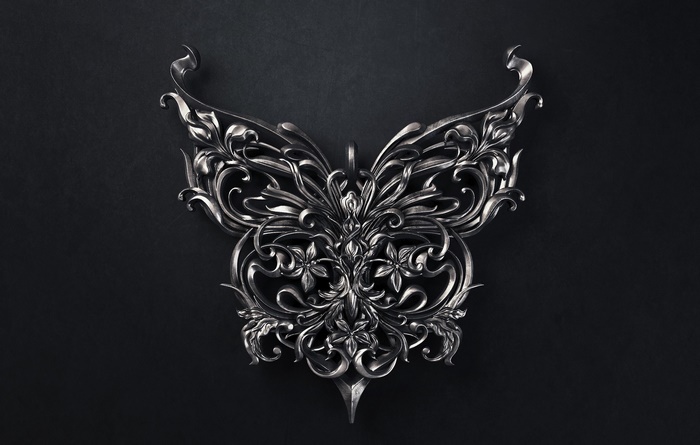 Ornate silver butterfly sculpture on dark background