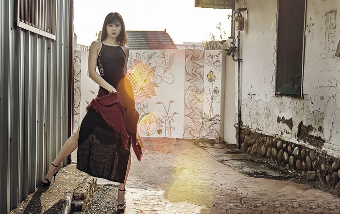 Asian woman in black dress posing outdoors