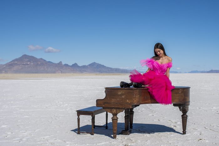 Olivia Rodrigo on a piano in a desert
