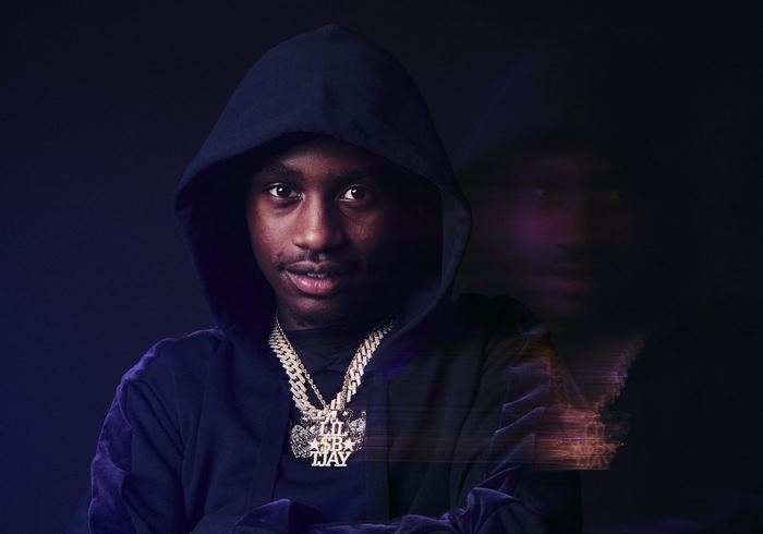 Lil Tjay wearing a hoodie and chains