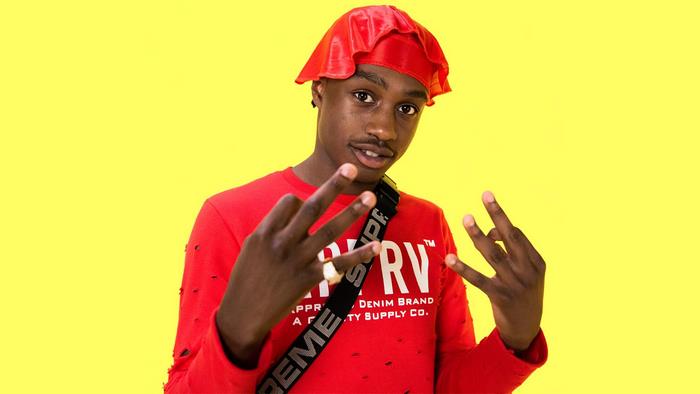 Lil Tjay wearing a red durag and shirt
