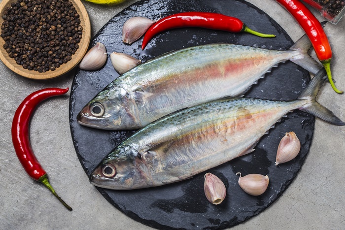 Two fresh fish with chili peppers and garlic