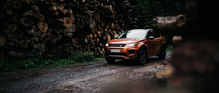 Orange Land Rover Discovery Sport on a dirt road