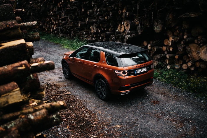 Orange Land Rover Discovery parked on a gravel road