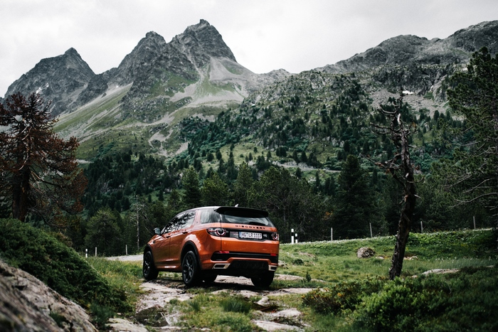 Orange Land Rover Discovery Sport on a mountain road