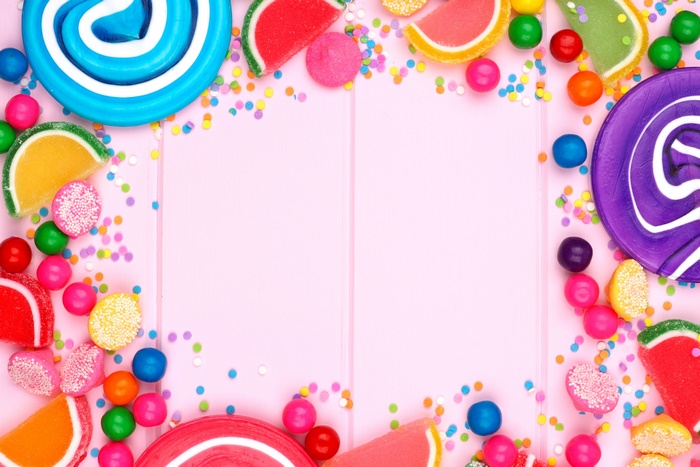 Colorful lollipops and candies on pink background