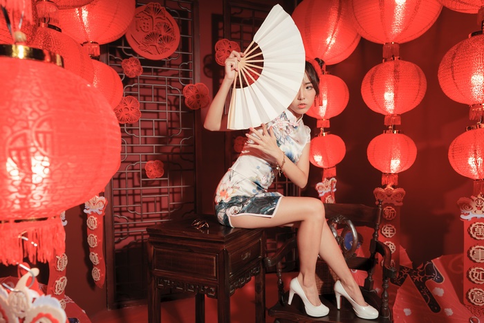 Asian Model in Cheongsam with Fan and Lanterns