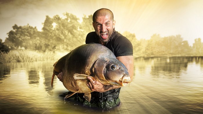Man holding a large carp in water