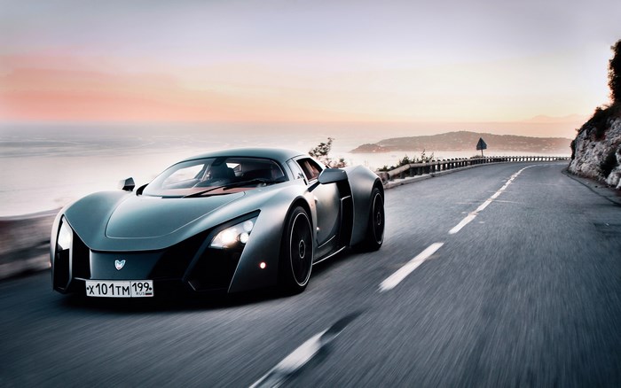 Marussia B2 sport car driving on coastal road