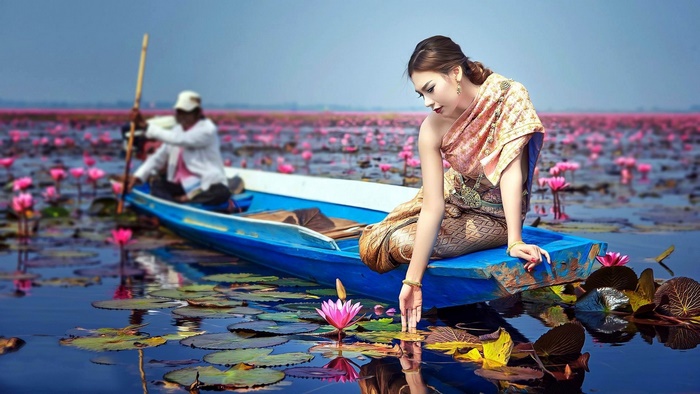Asian Woman on Boat in Lotus Pond