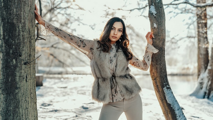 Woman in fur vest and floral shirt in winter forest
