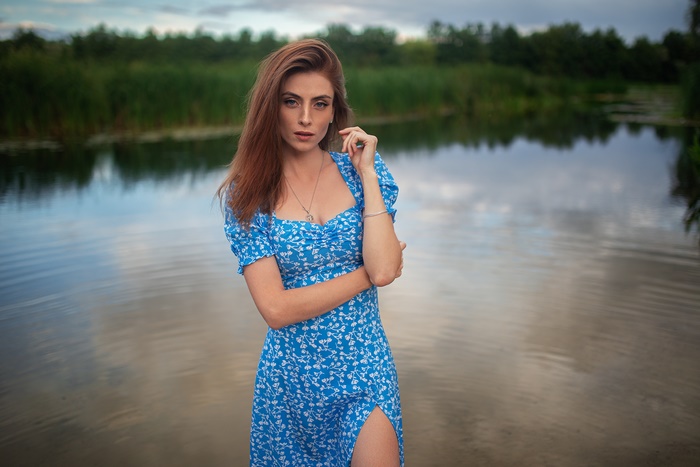 Redhead woman in blue dress by the water