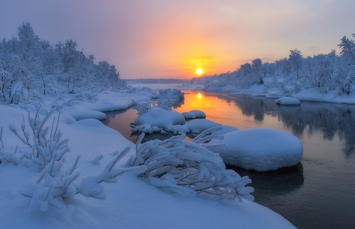 Winter river landscape at sunrise with snow-covered trees