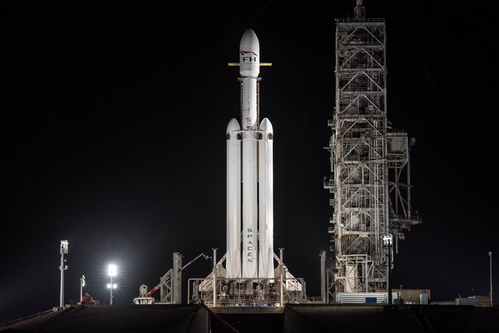 SpaceX Falcon Heavy rocket on launchpad at night