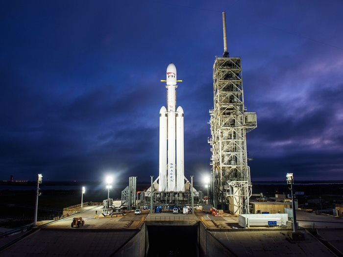 SpaceX Falcon Heavy rocket on launchpad at night